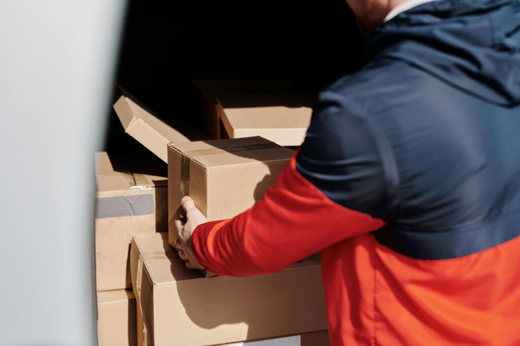 Man grabbin a moving box from the top of a pile